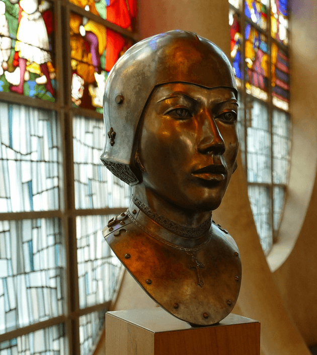 Visage en bronze représentant Jeanne d'Arc, femme croyante brulée à Rouen.