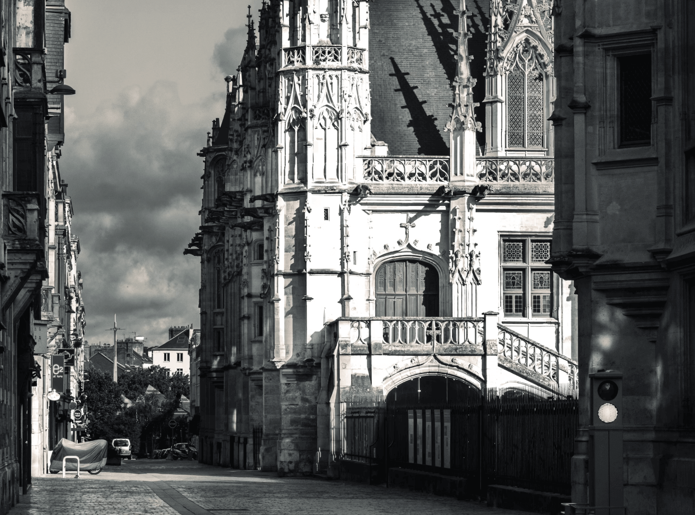 Ruelle devant le Palais de Justice : chef-d’œuvre gothique flamboyant aux riches ornements sculptés, témoin de l’histoire judiciaire et médiévale de Rouen, avec ces commerces sur le côtés.
